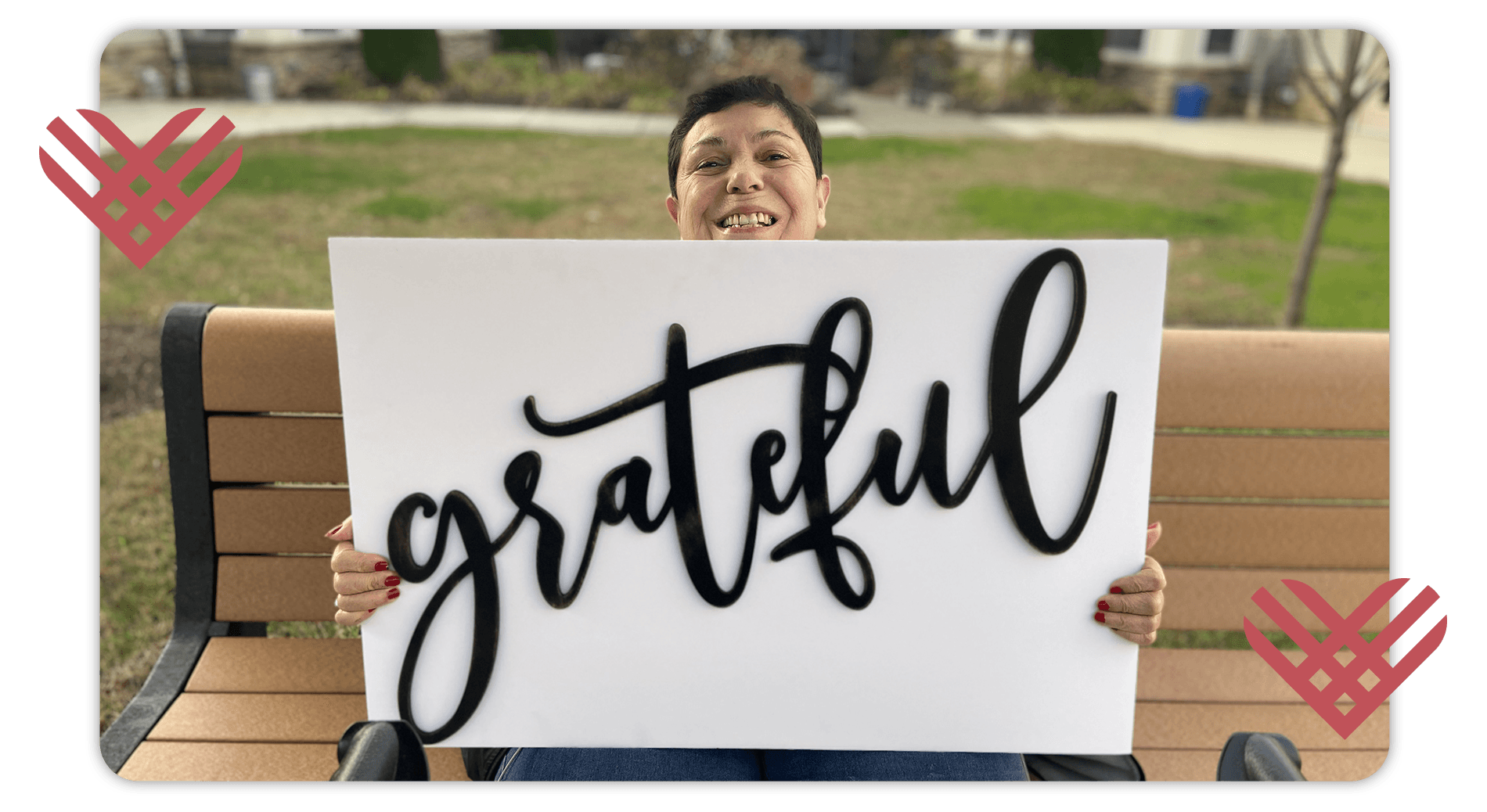Woman sitting on a bench holding a sign that says grateful